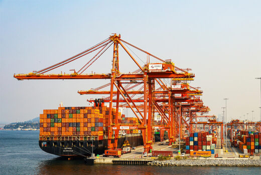 Contain ship at port being loaded with containers